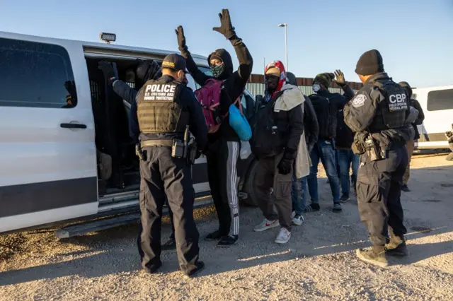 Un oficial de Aduanas y Protección Fronteriza de EE.UU. revisa a inmigrantes antes de transportarlos desde la frontera entre EE. UU. y México el 08 de diciembre de 2023 en Lukeville, Arizona. (Foto de John Moore/Getty Images)