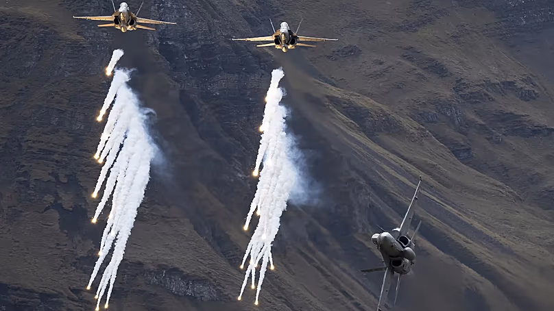 McDonnell Douglas F/A-18C Hornet fighter jets of the Swiss Air Force drop flares during the annual airshow of the Swiss Army in the Axalp area near Meiringen, 18 October, 2023