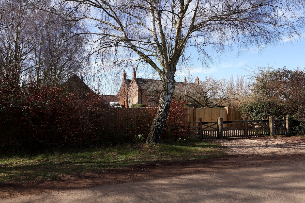 Árboles bordean unas puertas de madera recién instaladas en medio de las obras de renovación en Marsh Farm, en la finca de Sandringham, donde se espera que se mude Andrew Mountbatten-Windsor, antes conocido como el príncipe Andrés, en Norfolk, Gran Bretaña, el 17 de marzo de 2026. (REUTERS/Chris Radburn)