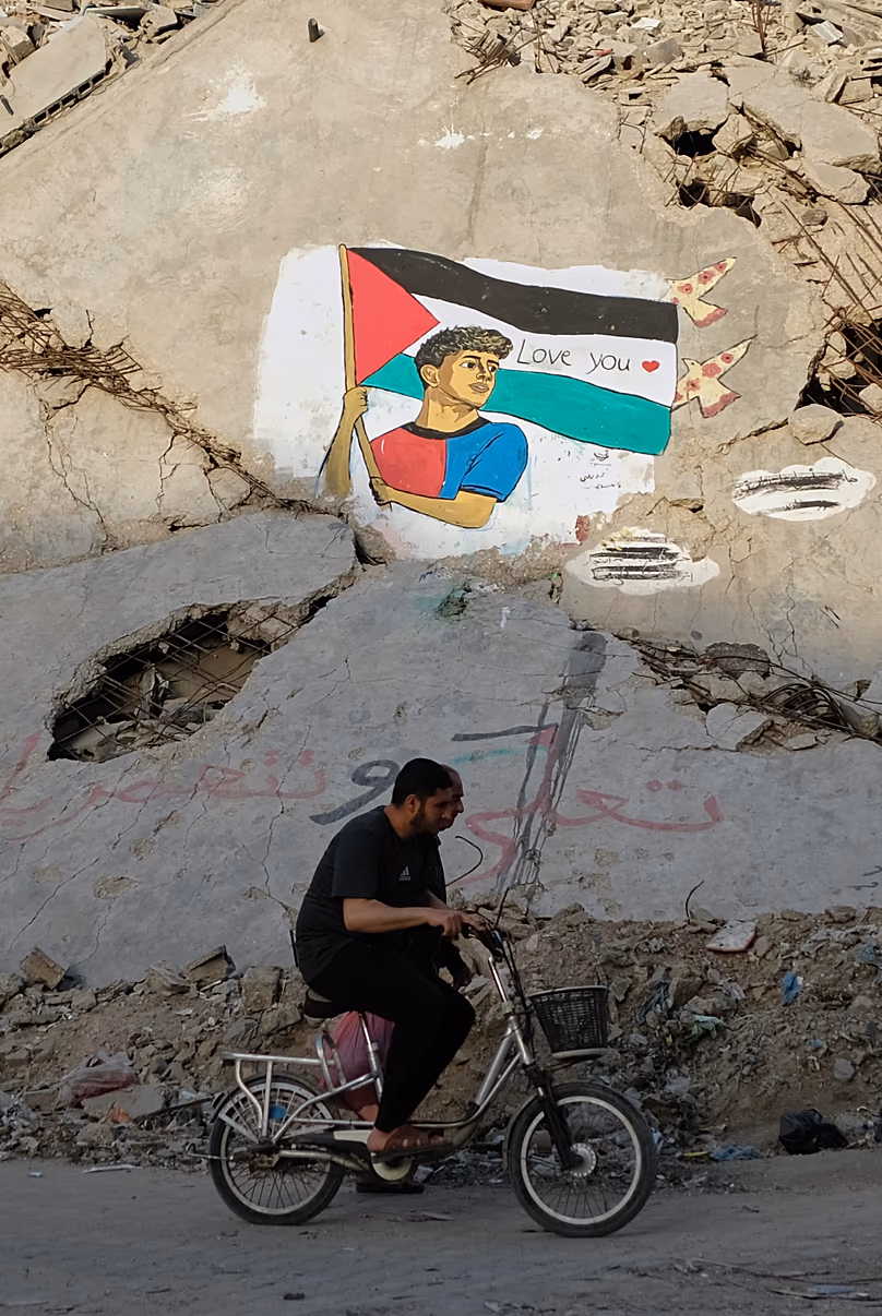 Un mural que representa al jugador de fútbol del FC Barcelona, Lamine Yamal, sosteniendo la bandera palestina sobre los escombros de un edificio destruido en el norte de la ciudad de Gaza, jueves 14 de mayo de 2026