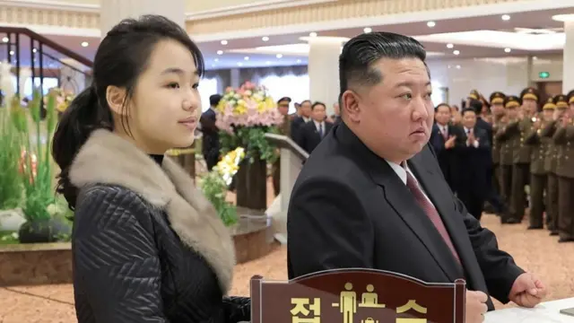 Padre e hija juntos en un hotel rodeados por militares.