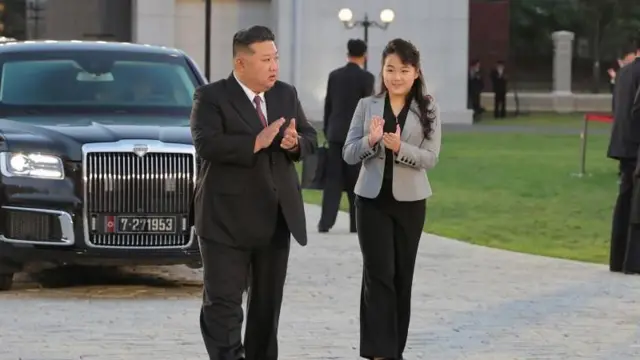 Kim Jong Un con su hija caminando mientras aplauden.