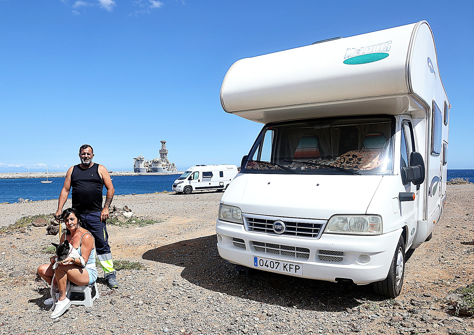 Herminda Bouzas, su marido, Néstor, y la perra Aquila junto a la caravana en la que viven al lado del Puerto de Granadilla.