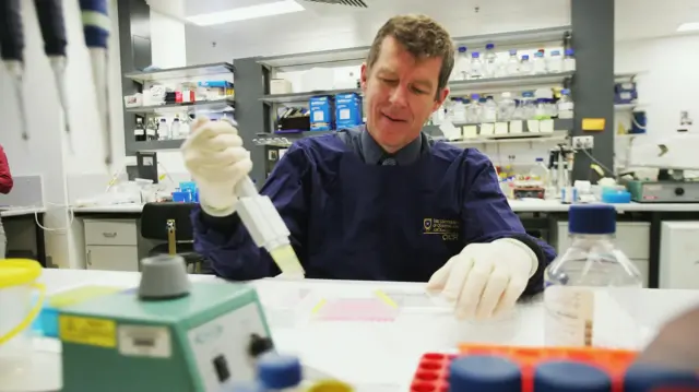 El profesor Ian Frazer, con guantes, haciendo una prueba en un laboratorio