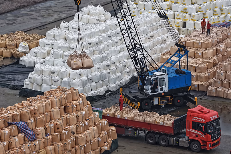 Workers transfer bags of imported solid sulfur onto a truck in a port in Nanjing in eastern China's Jiangsu province, April 14, 2026. (Chinatopix Via AP) 