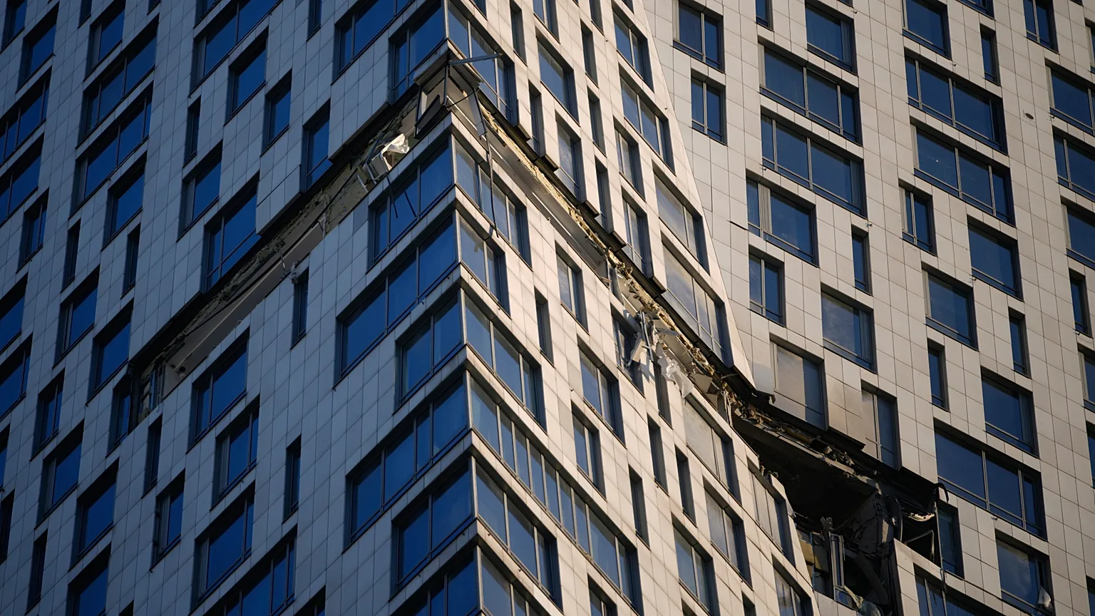 Debris dangles from a damaged apartment building on Mosfilmovskaya street after a Ukrainian drone attack in Moscow, Monday, May 4, 2026.