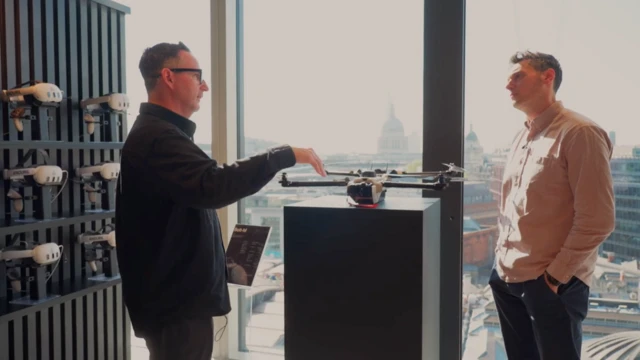 Joe Tidy y Richard Drake en la sede principal de Anduril en Londres, de pie frente a un dron.
