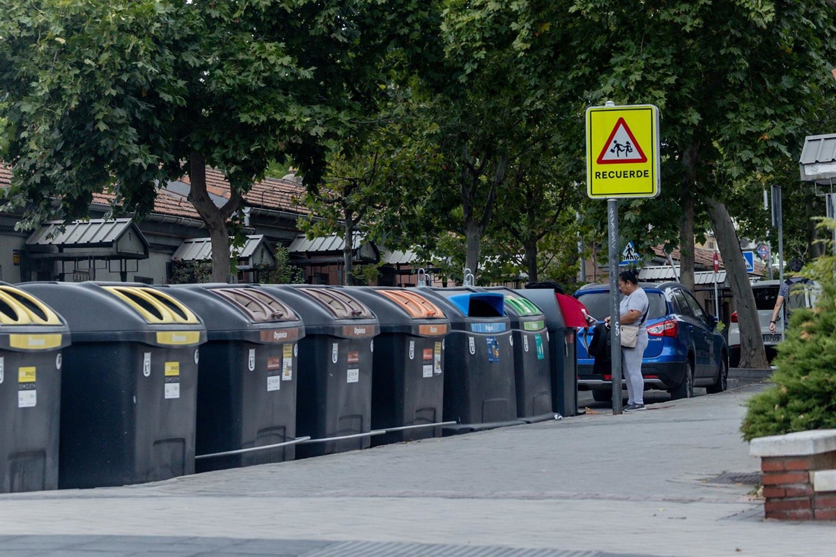 Una mujer tira basura en unos contenedores en una calle de Madrid (Ricardo Rubio / Europa Press)