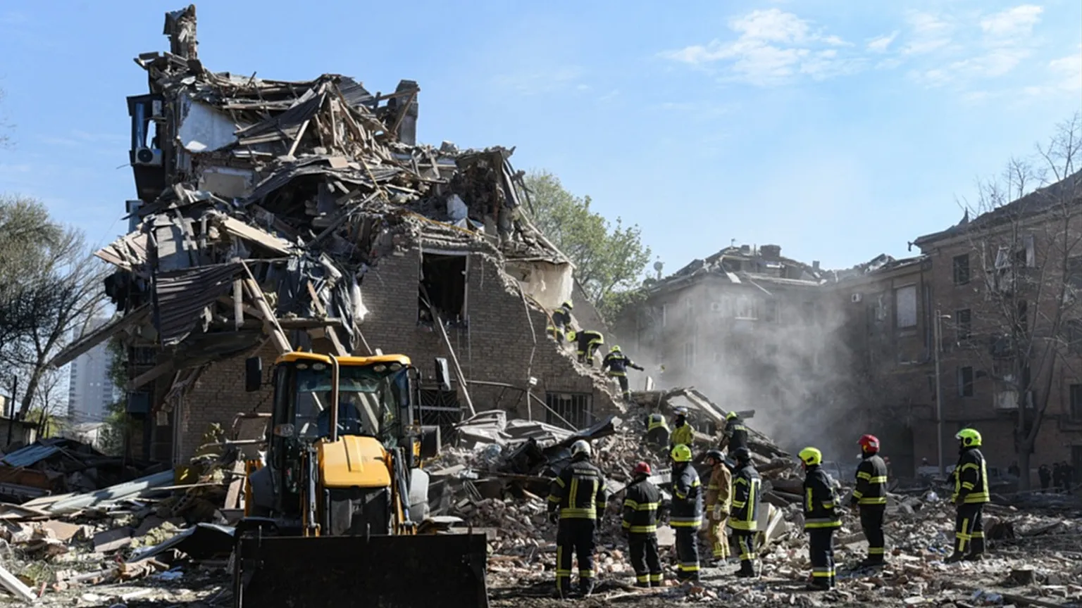 Rescue workers clear the rubble of a residential building destroyed by a Russian strike, in Dnipro, Ukraine, Saturday, April 25, 2026