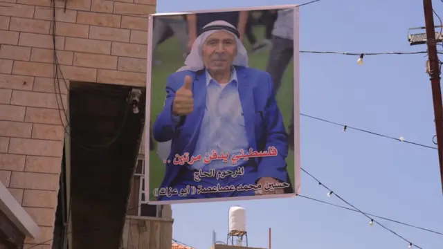 Una fotografía enmarcada de Hussein Asasa colgada en la pared