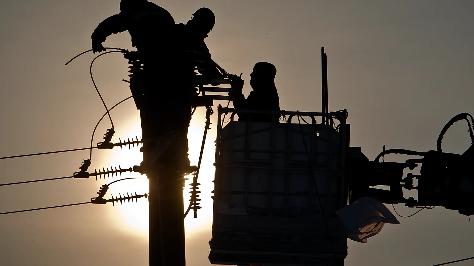 Employees of the national electricity distributor work in freezing temperatures to fix power lines damaged by blizzards, near Pitulicea, Romania, Wednesday, Feb. 15, 2012.