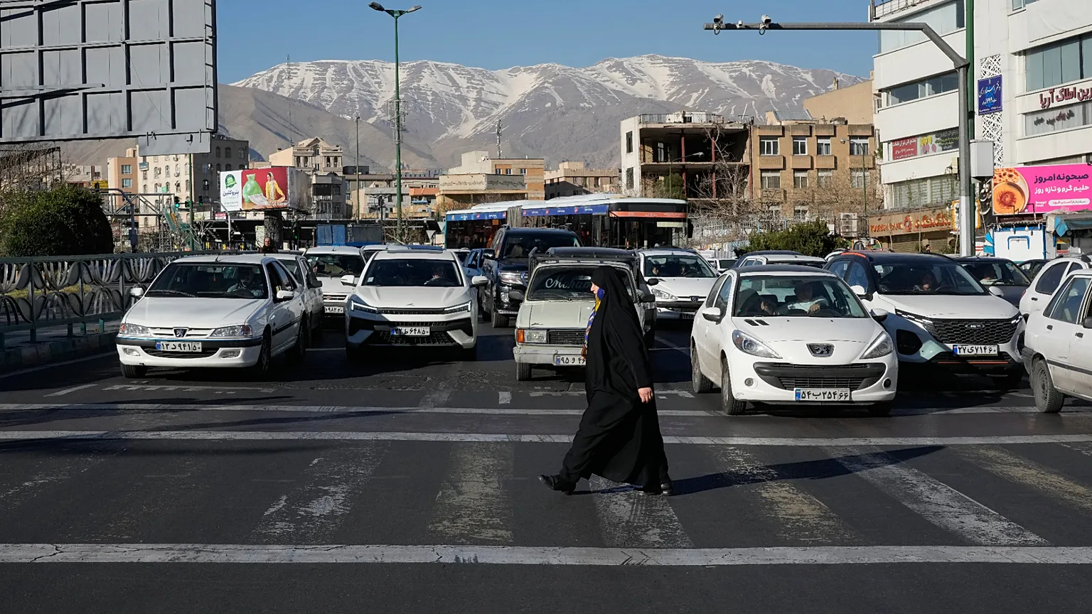 A woman crosses a street in Tehran, Iran, Thursday, Feb. 26, 2026. (AP Photo/Vahid Salemi)