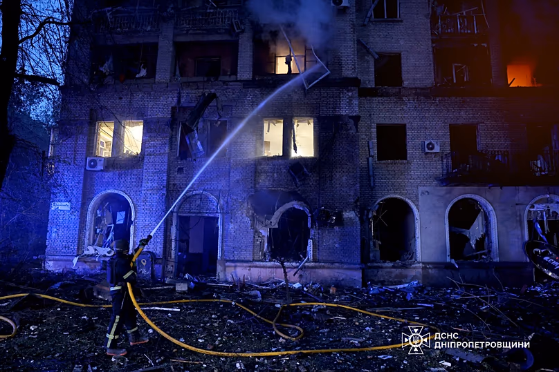 Rescue workers put out a fire of a residential building damaged after a Russian strike on Dnipro, 18 May, 2026