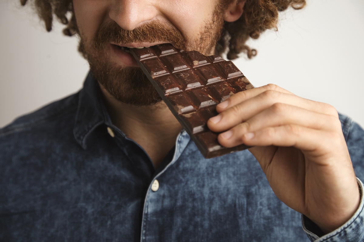 Un hombre comiendo una tableta de chocolate