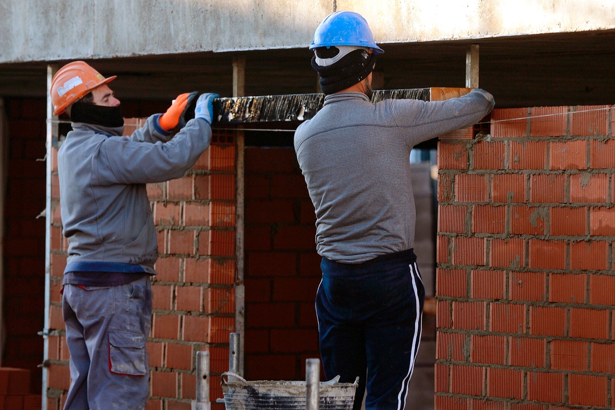 Dos albañiles trabajan en una obra. (EFE/Nacho Gallego)
