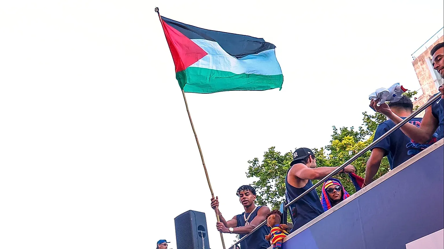 FC Barcelona player Lamine Yamal holds a Palestinian flag as he celebrates with his team atop a bus after winning the Spanish La Liga title in Barcelona, 11 May, 2026