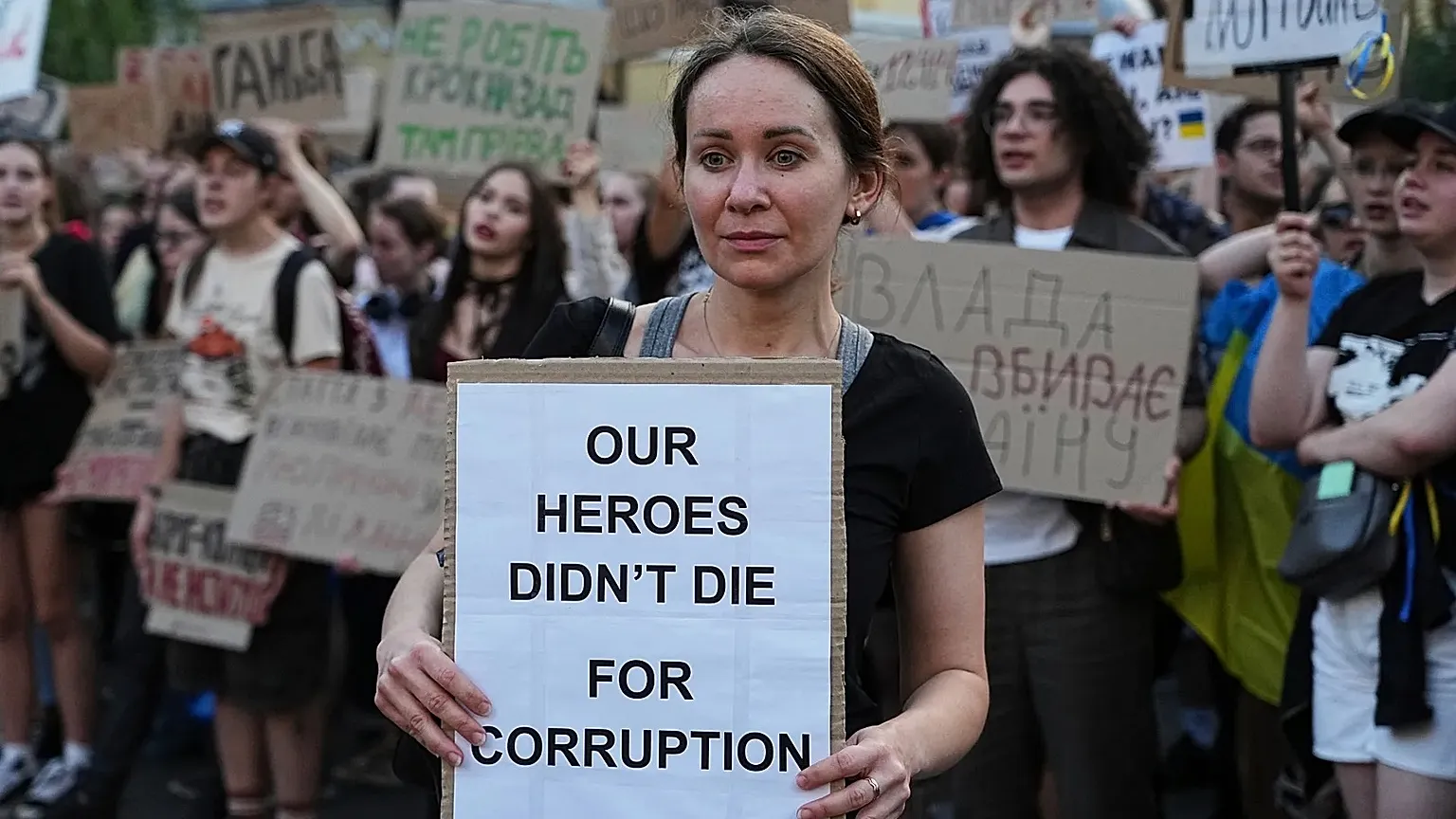 FILE: A woman holds a banner during a protest against a law targeting anti-corruption institutions in central Kyiv, Ukraine, Wednesday, July 23, 2025