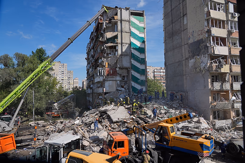 Rescuers clear the rubble after a Russian missile hit an apartment building during massive air attack in Kyiv, 14 May, 2026
