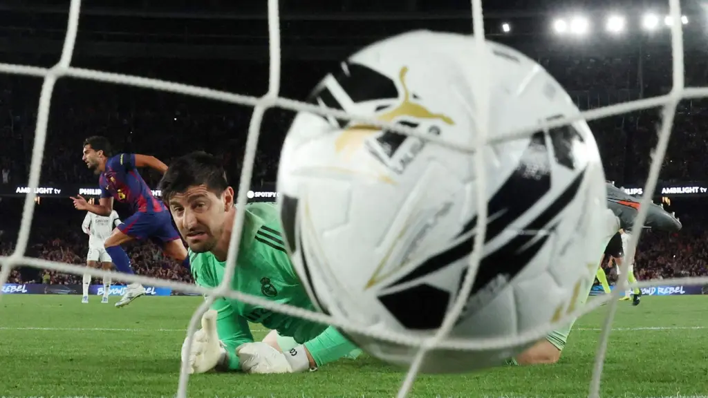 Thibaut Courtois mira el balón dentro de su portería en el gol de Ferran Torres en El Clásico
