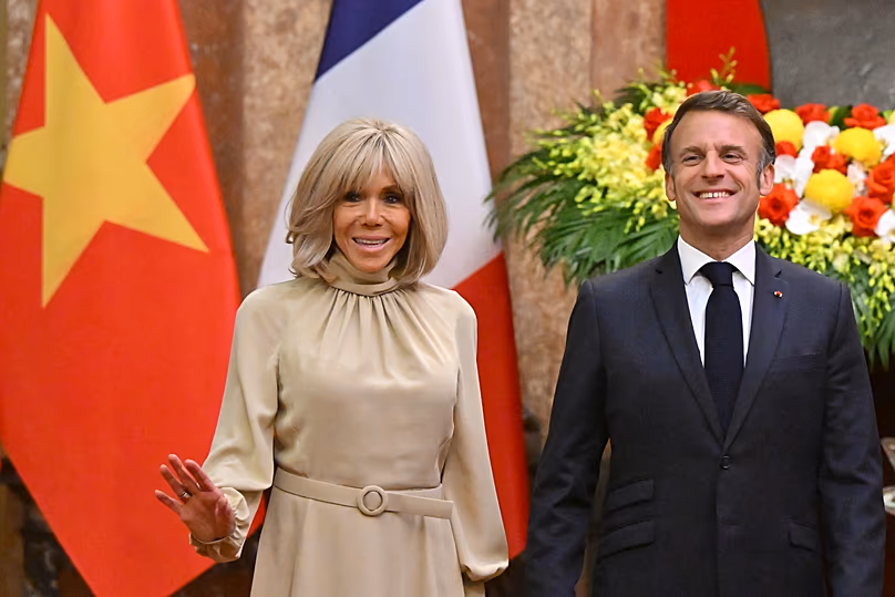 France's President Emmanuel Macron and his wife Brigitte Macron pose for photos at the Presidential Palace in Hanoi, 26 May, 2025