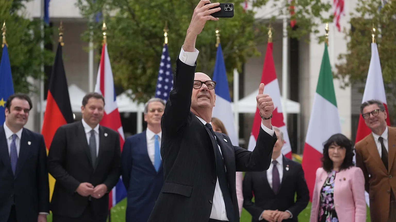 French Finance Minister Roland Lescure takes a selfie picture as G7 Finance Ministers and Central Bank Governors pose for a family photo at the G7 finance meeting in Paris