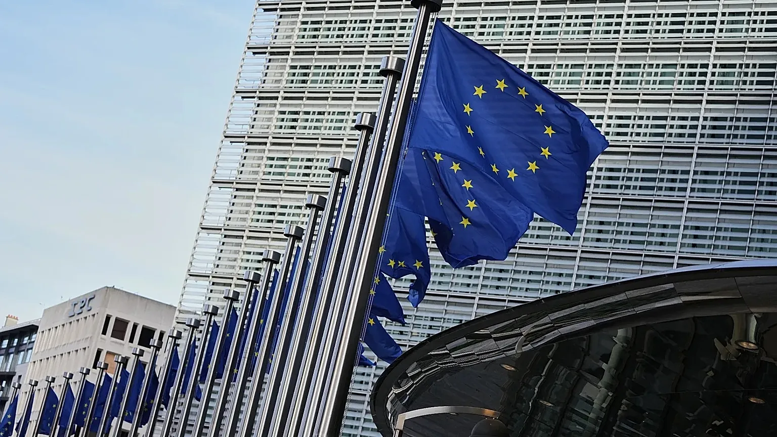 European Union flags flap in the wind outside of EU headquarters in Brussels, 4 November, 2025
