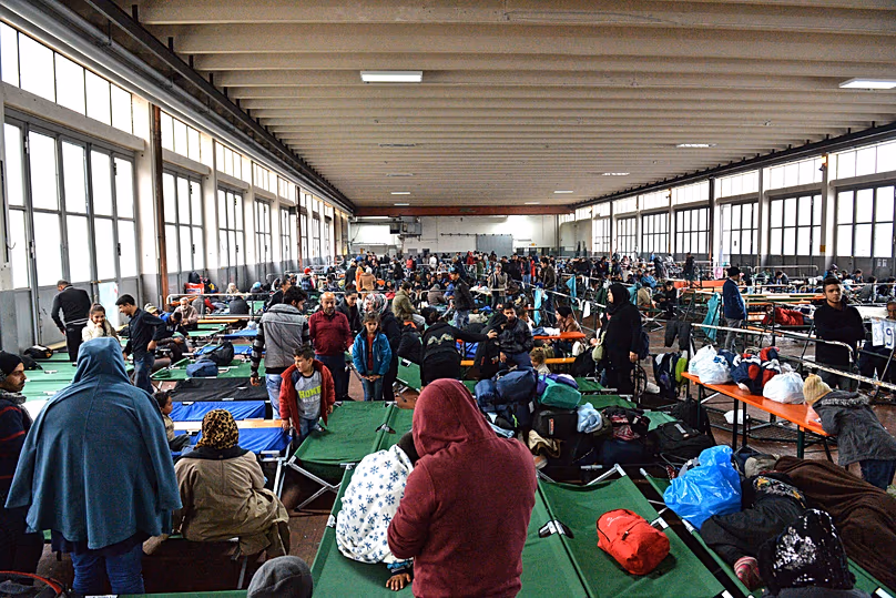Refugees wait in a crowded migrant registration centre in Passau, 8 October, 2015