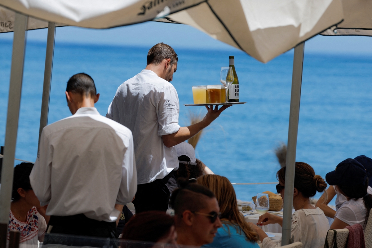 Camareros sirven bebidas a los clientes en la terraza de un restaurante de Málaga. REUTERS/Jon Nazca