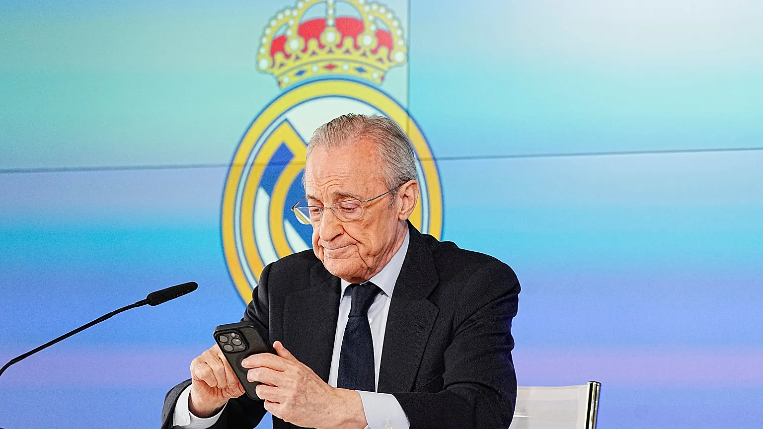 Real Madrid president Florentino Perez reads news on his phone during a press conference in Madrid, Tuesday, May 12, 2026. (AP Photo/Bernat Armangue)