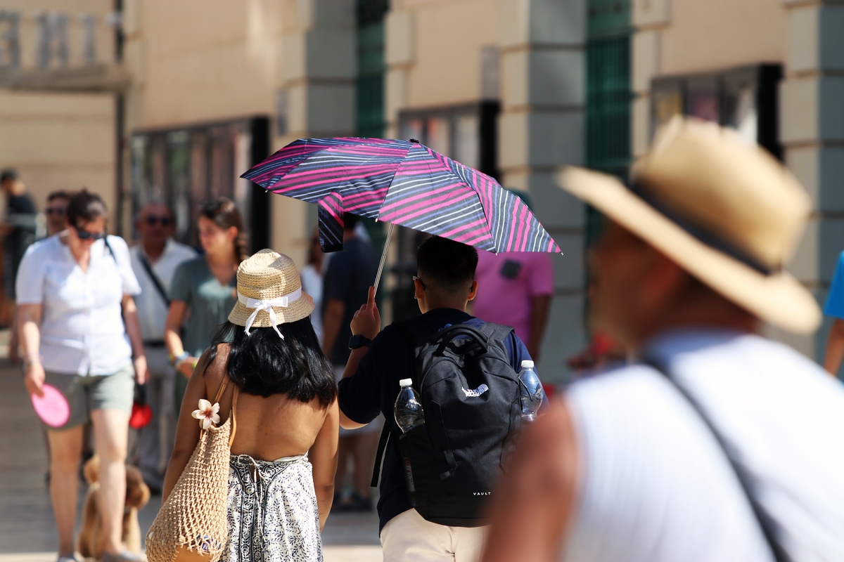 Imagen de archivo de viandantes soportando las altas temperaturas por las calles de Málaga. (Álex Zea/Europa Press)