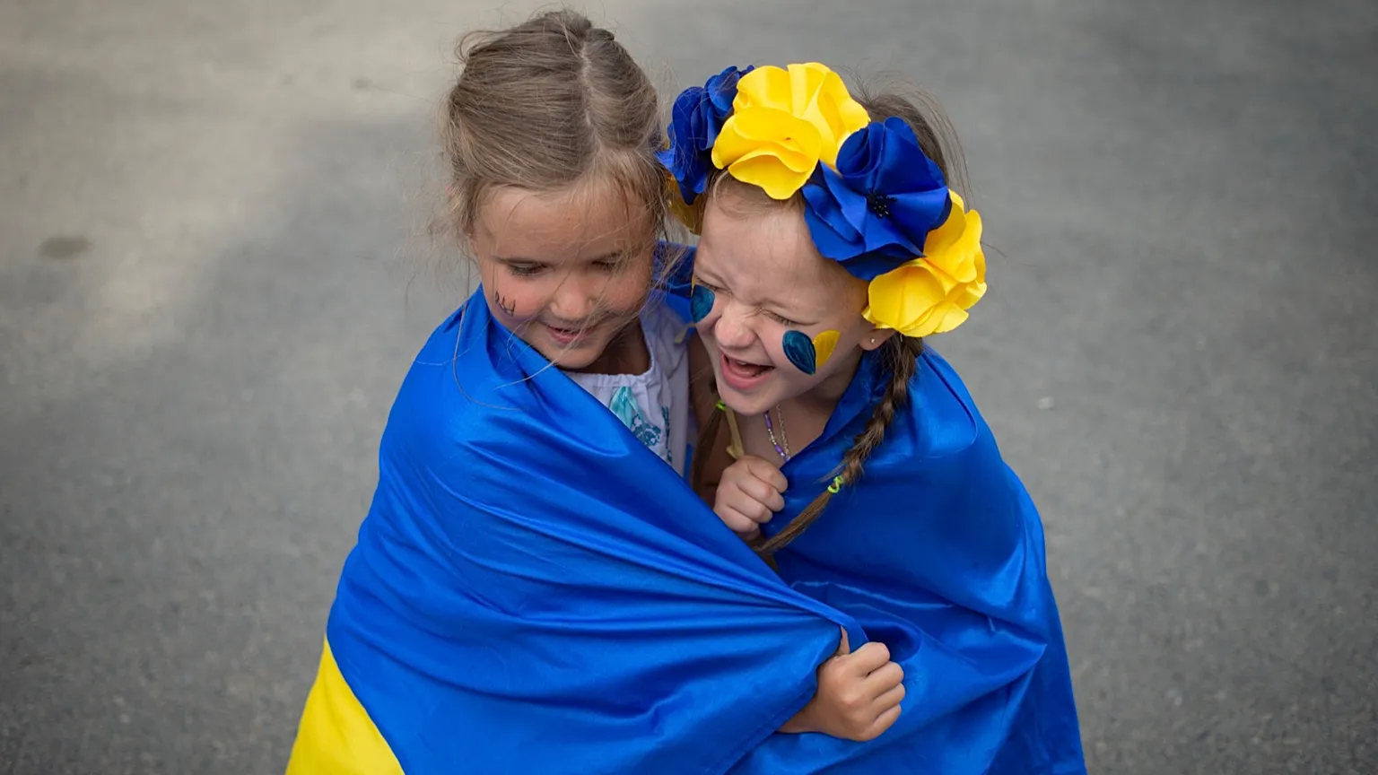  FILE: Ukrainian refugee children play wrapped in Ukraine's flag, Bucharest, Romania, , Aug. 24, 2022. 