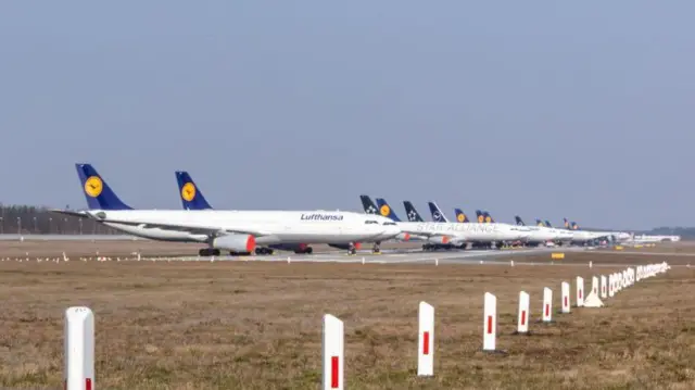 Aviones de la aerolínea alemana Luftfansa estacionados en un aerropuerto.