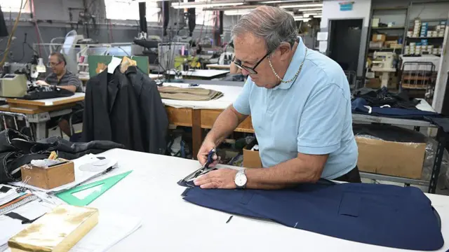 Un hombre confeccionando un traje en Argentina.