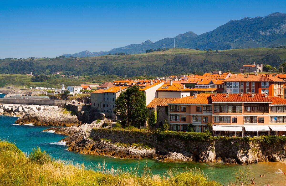 Foto: Casas de teja roja frente al Cantábrico en una villa asturiana rodeada de acantilados. (iStock)