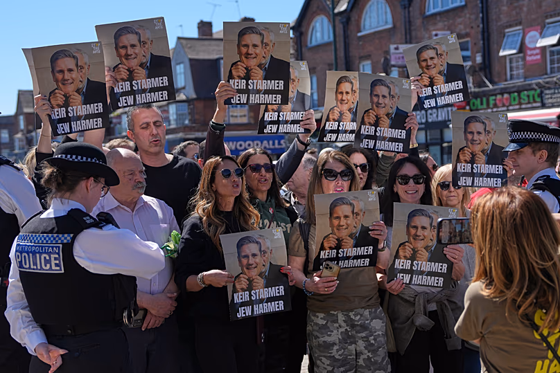 Protesters hold posters near the scene where two people were stabbed yesterday in the Golders Green neighbourhood, 30 April, 2026