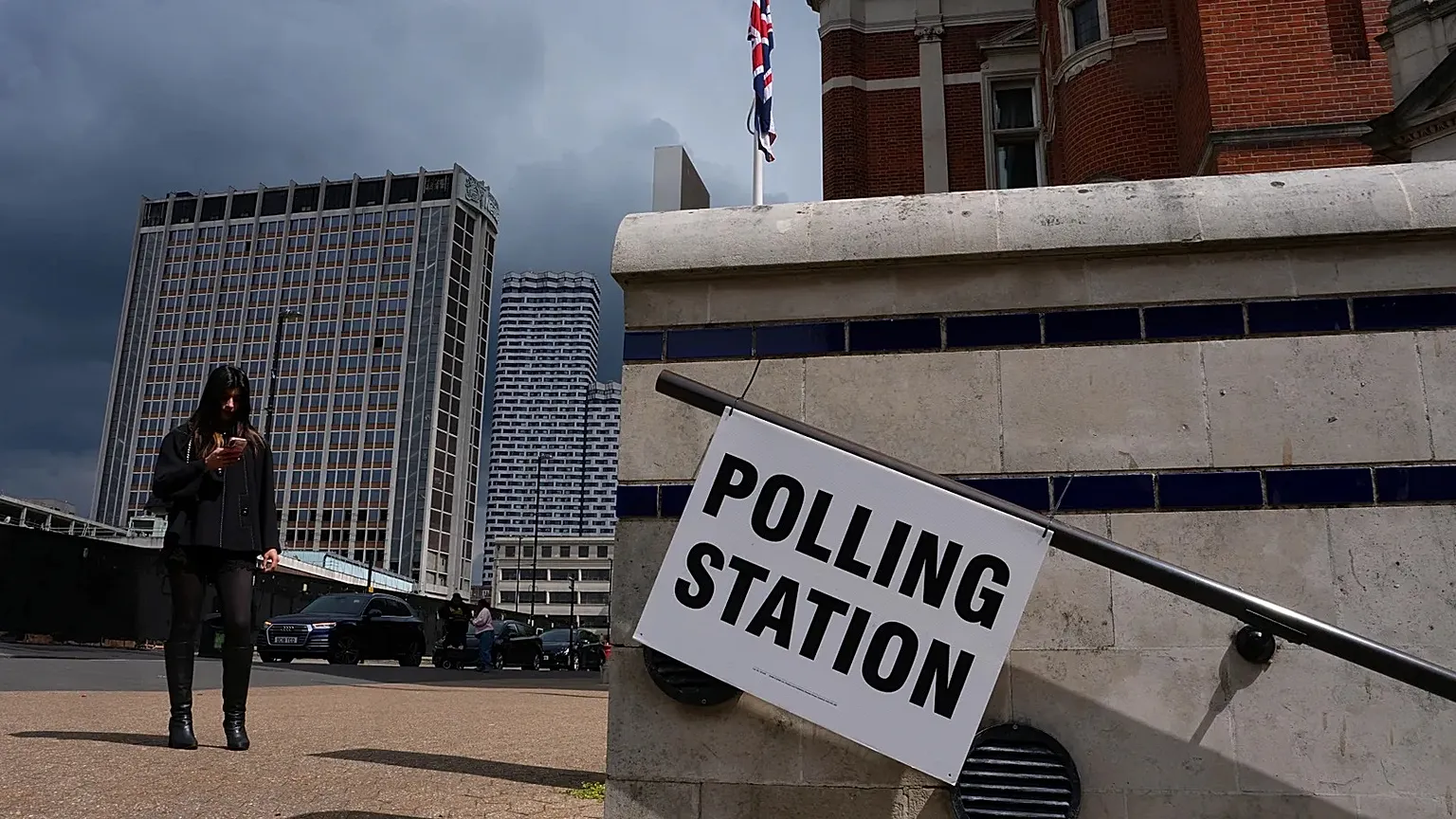 A pedestrian walks past a polling station sign in London, 7 May, 2026