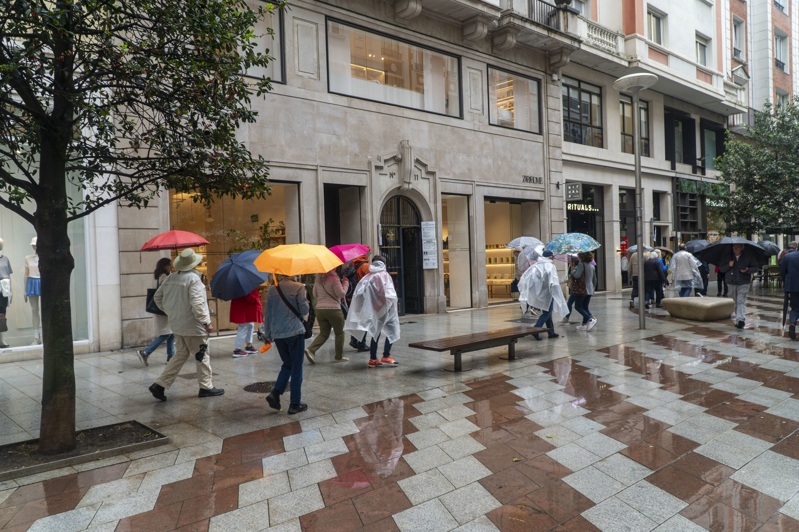 Gente caminando bajo la lluvia en Santander.