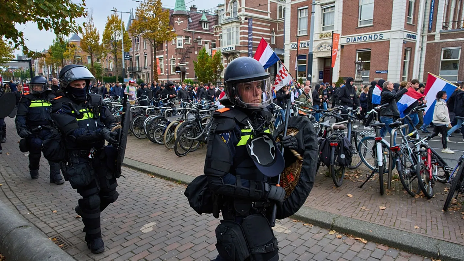 FILE - Dutch riot police escort anti-immigration protesters during a demonstration in Amsterdam, Netherlands, 12 Oct 2025