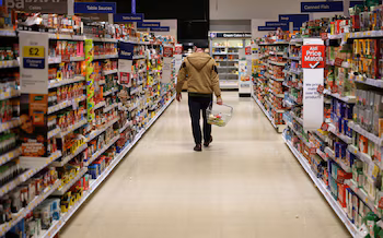 FOTO DE ARCHIVO. Un hombre camina a lo largo de un pasillo dentro de un supermercado (REUTERS/Phil Noble)