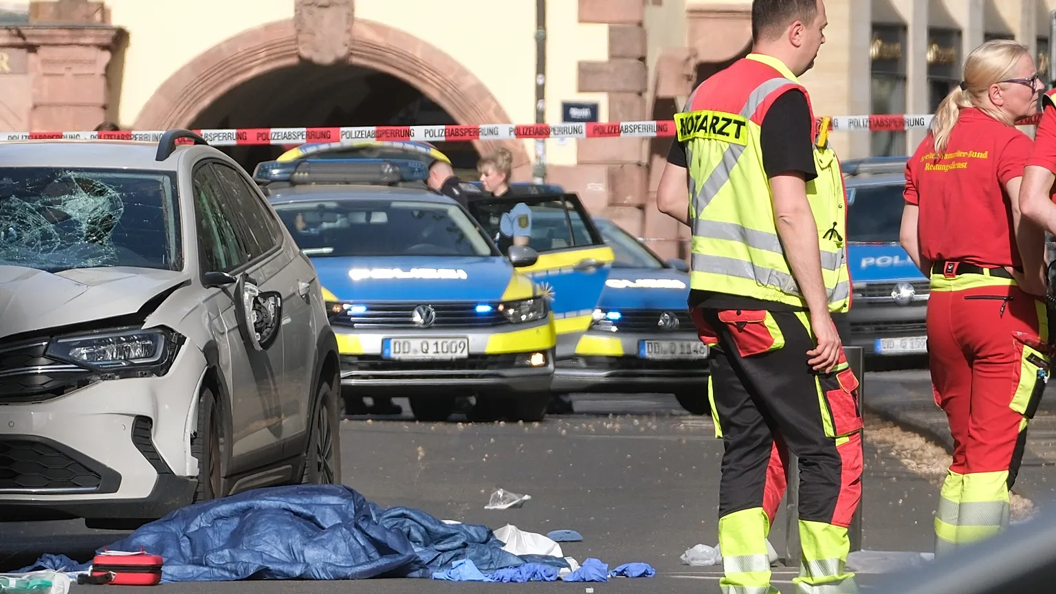 Rescue workers stand next to a damaged car that has crashed into several people in Leipzig, Germany, Monday, May 4, 2026.