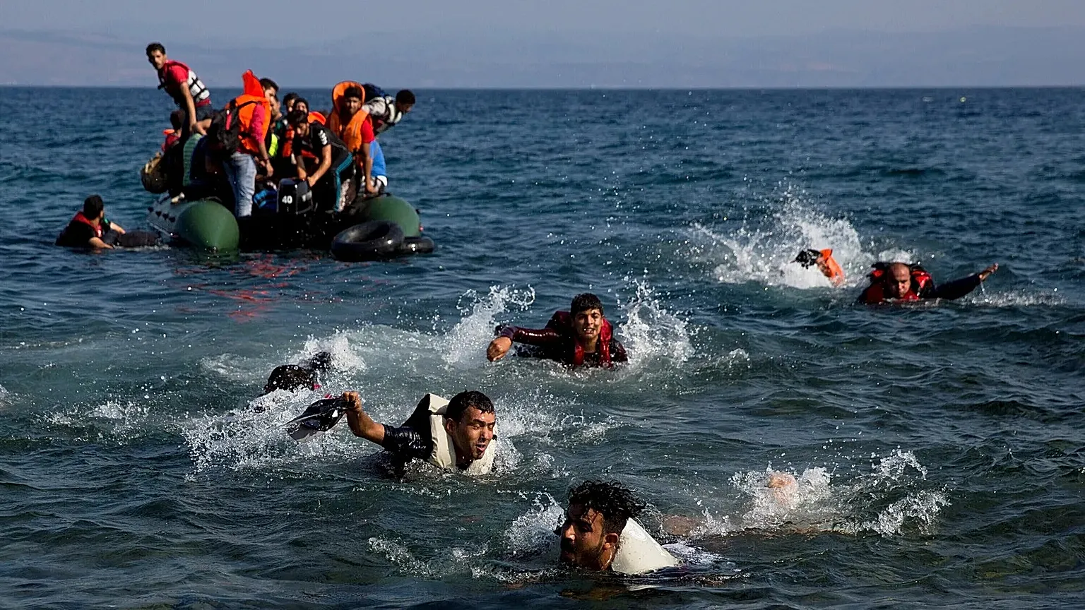Migrants whose boat stalled while crossing from Turkey to Greece swim to the island of Lesbos, 20 September, 2015