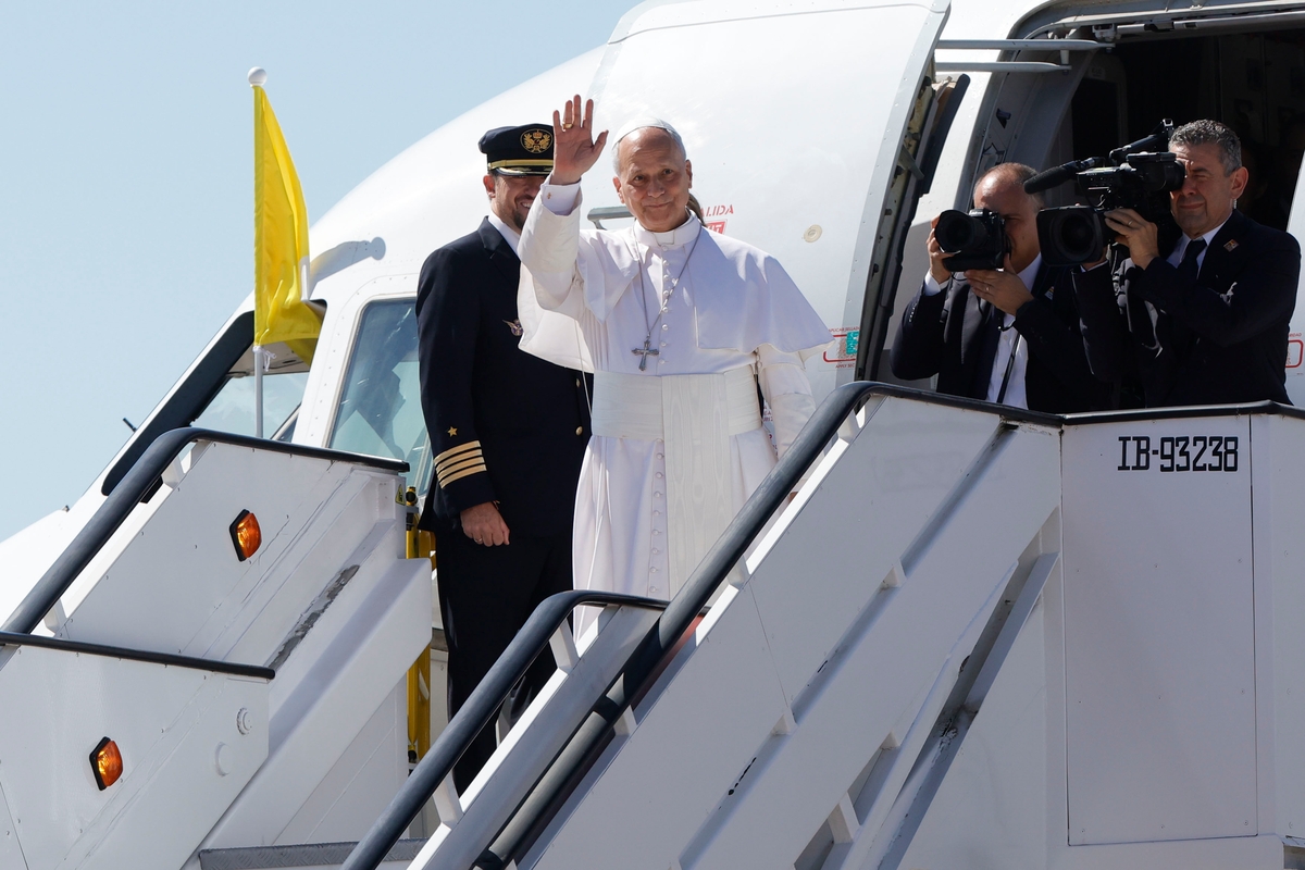 El papa León XIV saluda mientras sube abordo de un avión con destino a Barcelona. (EFE/Zipi)