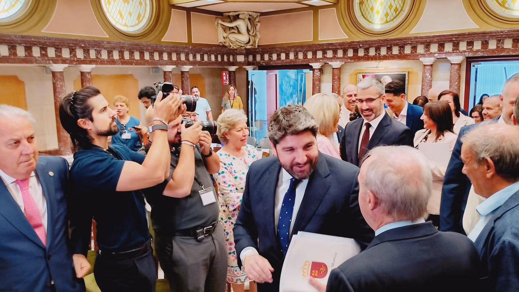López Miras, saludando al público asistente al Debate del Estado de la Región, justo por detrás, el líder del PSOE, Francisco Lucas.