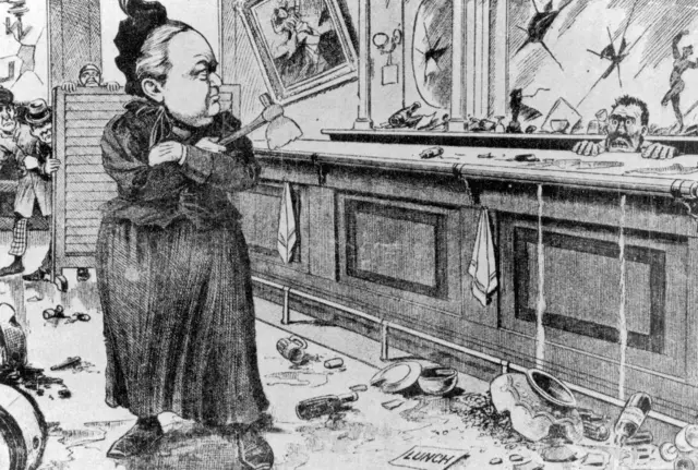 Una caricatura antigua en la que se representa a Carrie Nation, con un hacha en la mano, en una cantina destrozada. el bartender la mira desde detrás de la barra con terror.