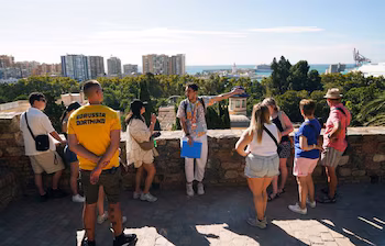 Grupo de turistas atendiendo a las explicaciones de un guía turístico. (Álex Zea / Europa Press)