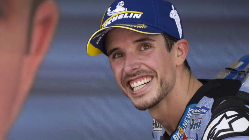 Álex Márquez, con su imagen proyectada en una pantalla gigante en un podio de MotoGP.