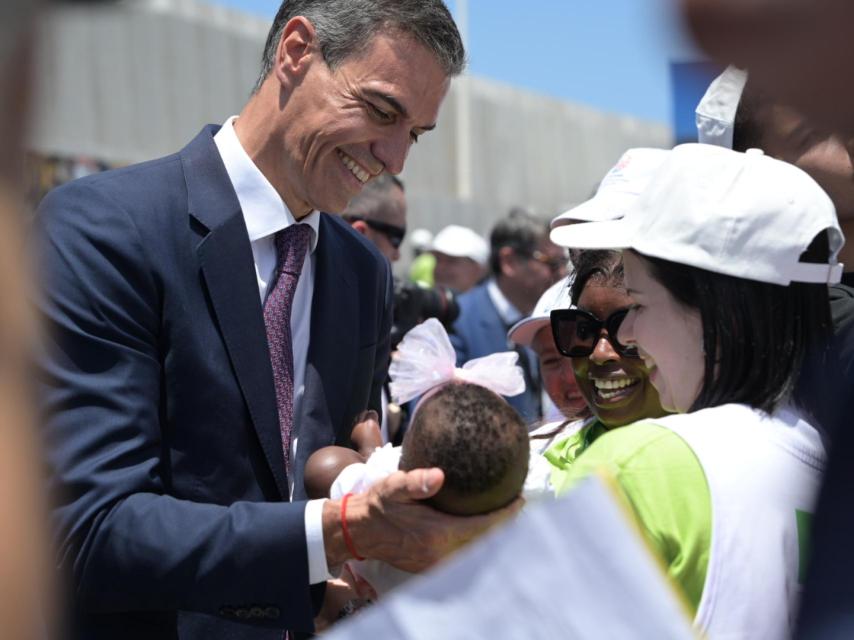 El presidente del Gobierno, Pedro Sánchez, con un bebé en la visita del Papa a Las Palmas de Gran Canaria.