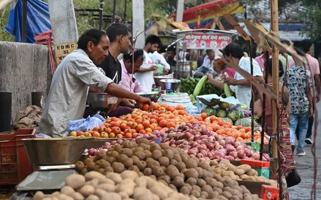 Personas comprando verduras en un mercado local.