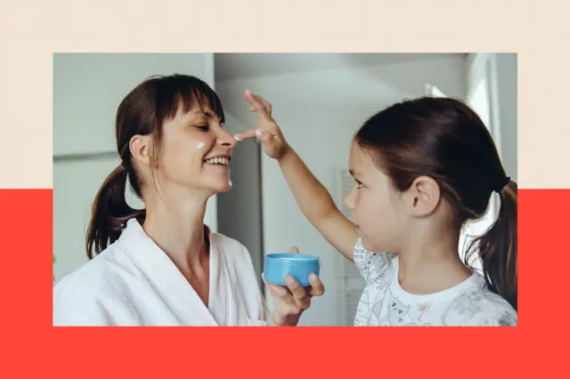 Hija aplicándole crema facial a su madre en el rostro.