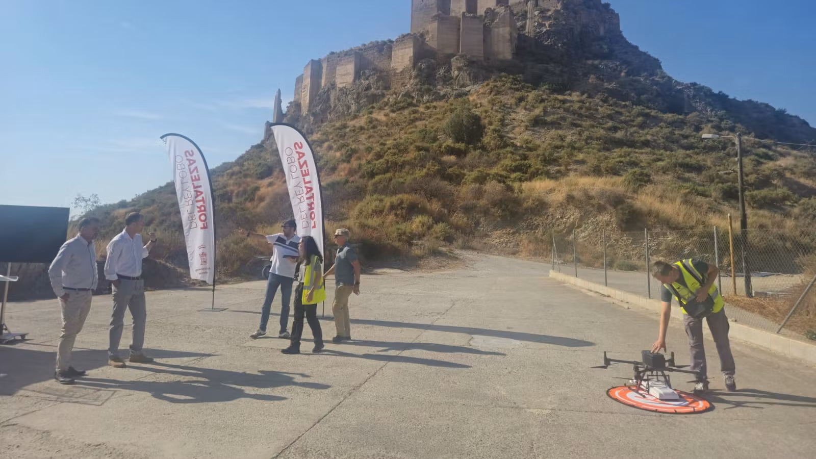 Técnicos y representantes institucionales supervisan el trabajo del georradar a los pies del castillo de Monteagudo.
